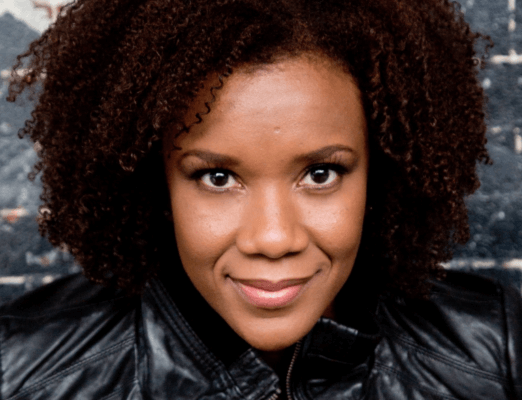 Close up of a Black woman with curly hair in a black shirt