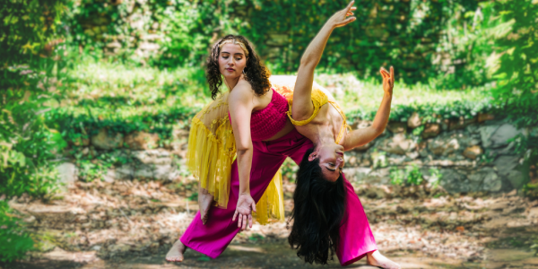 Two dancers in bright colors posing in the woods 