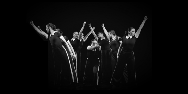 Black and white image of dancers with fists raised